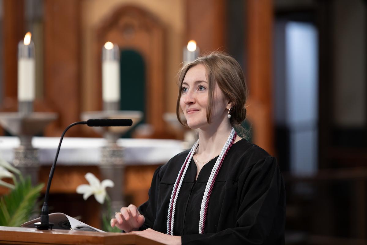 Student in graduation robes walking at baccalaureate in cathedral